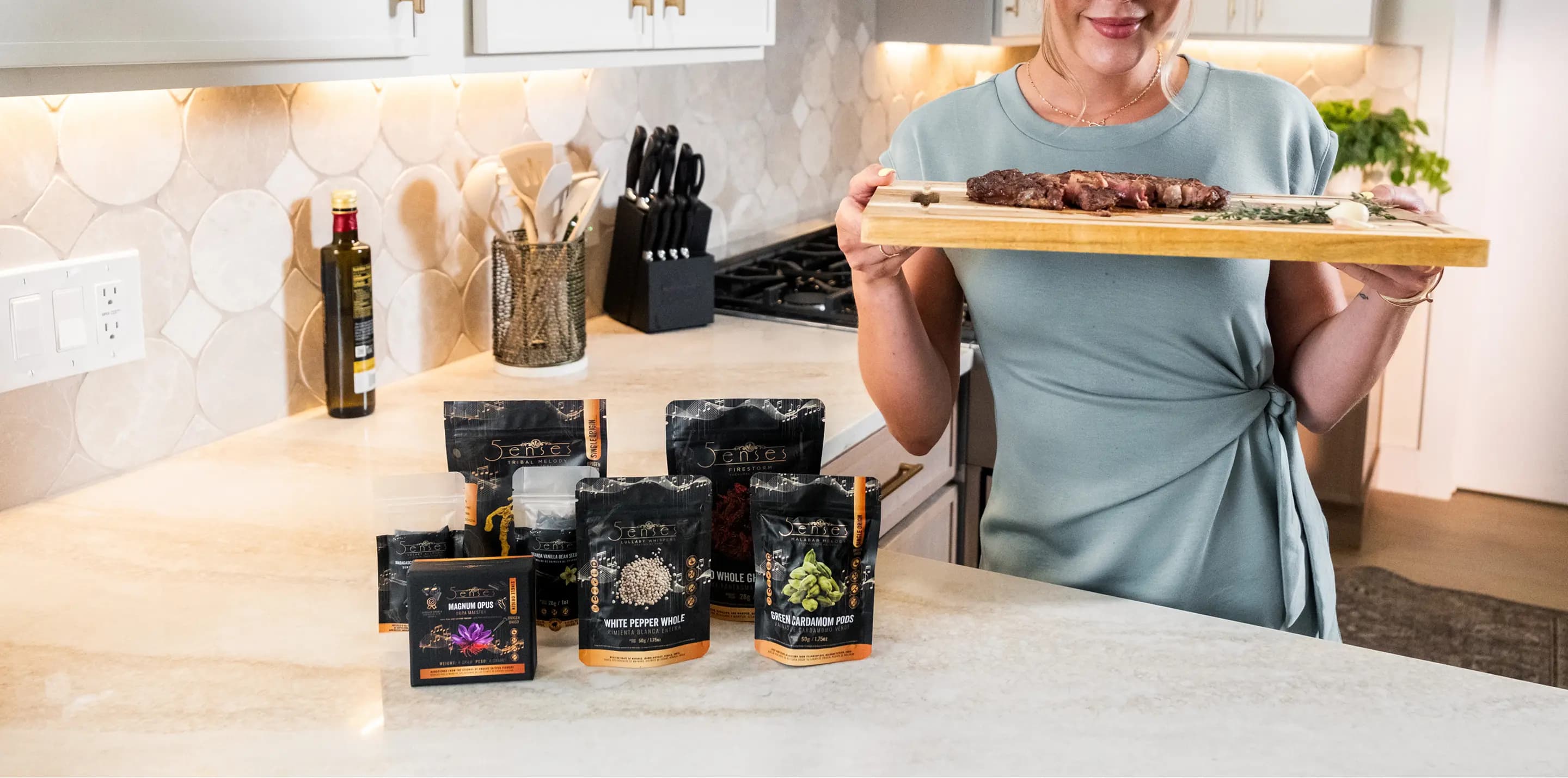 A wide shot of 5Senses pouches on the counter with a cook holding a chopping board