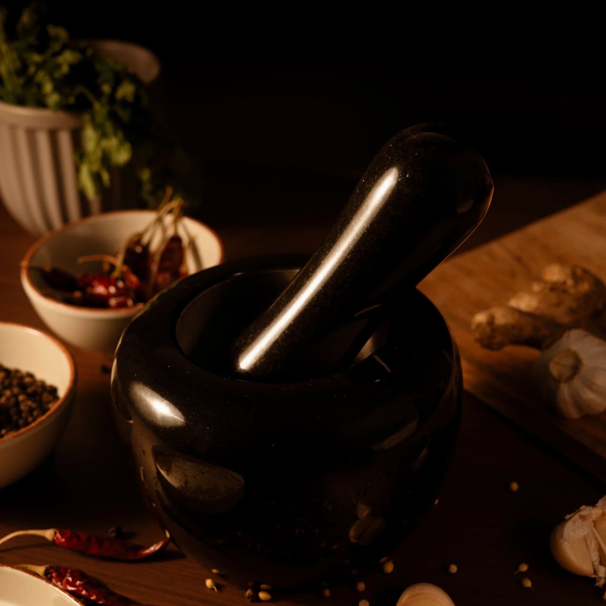 5Senses Adikal black granite mortar and pestle with garlic, ginger, chilies, and whole spices.